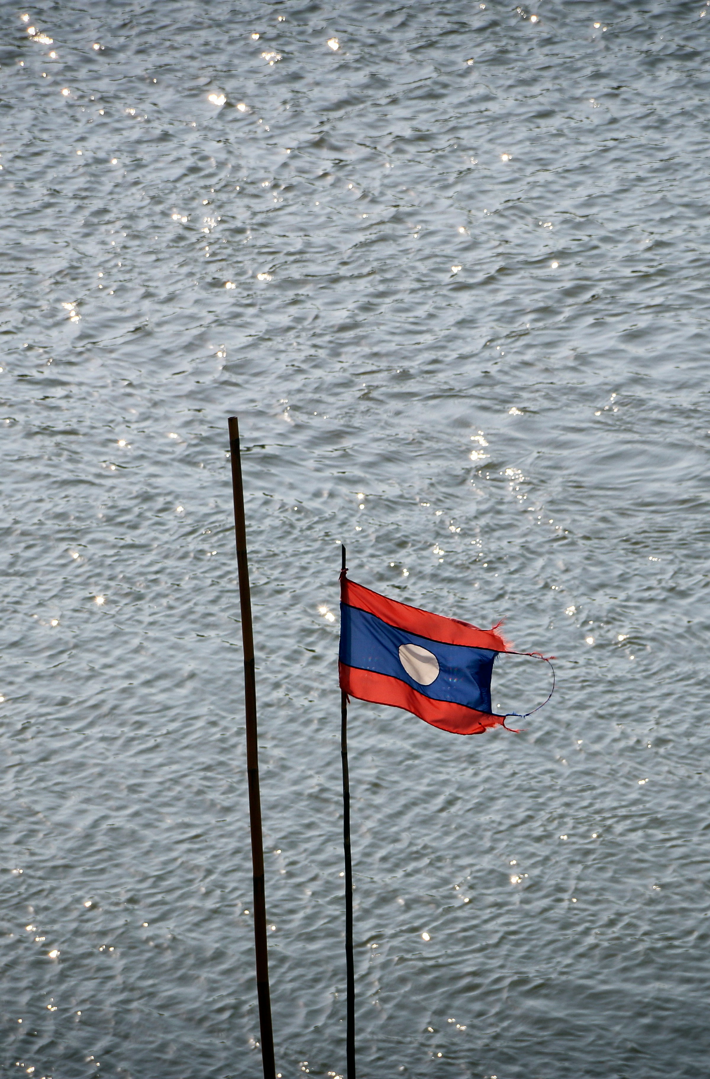 blue and red flag on pole on body of water